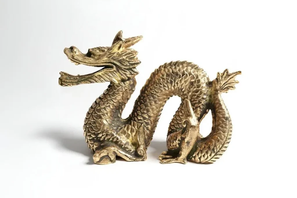 3D rendered golden brass Chinese dragon figurine with detailed scales and serpentine body on white background