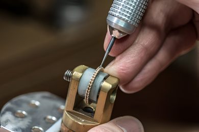 Artisan Setting Stones in a ring Jewelry artisan using precision tools to set diamonds in gold ring held in a vice clamp
