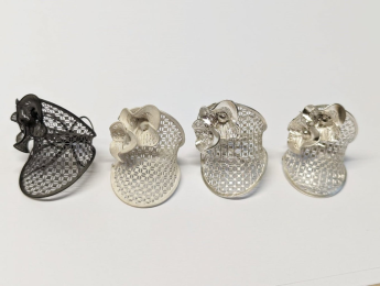 https://apmcastings.com/stone-settings/ Four stages of 3D printed jewelry production showing black resin prototype, white gold rough casting, and polished gold jewelry pieces